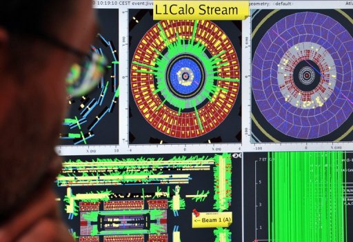 Một nhà khoa học đang nhìn vào các màn hình máy tính thể hiện các thí nghiệm tại CERN.